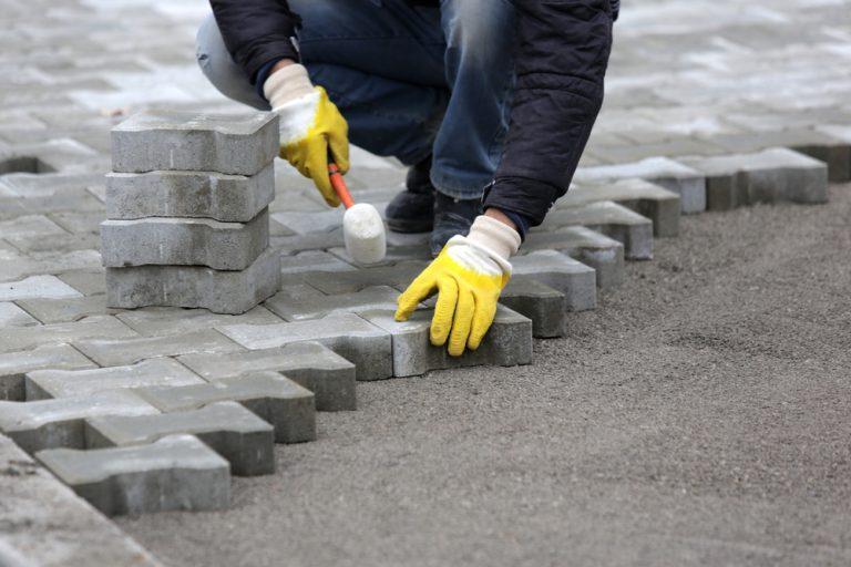 paving,stone,worker,is,putting,down,pavers,during,a,construction